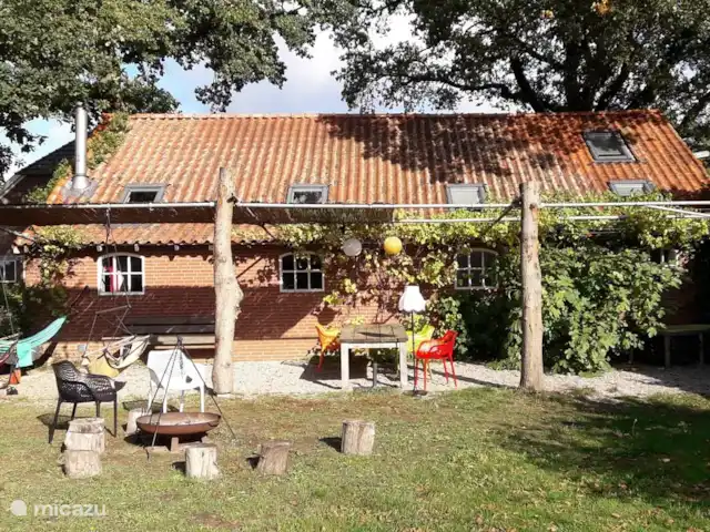Het terras ligt op het zuiden. Hangmat, buitetafel voor 6 gasten, ligbad en vuurplaats. (foto 2020)